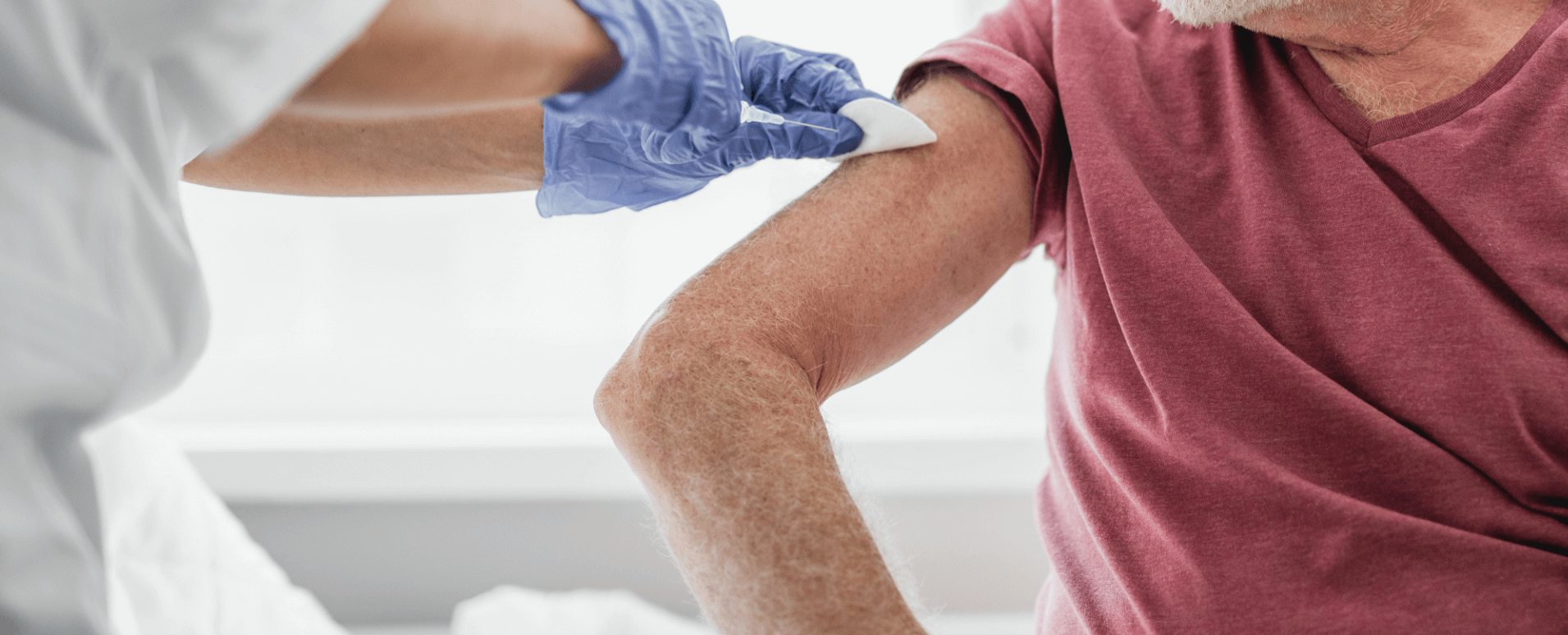 Sygeplejerske iført blå handsker udfører vaccination med vaccine, der passer til borgers ønsker
