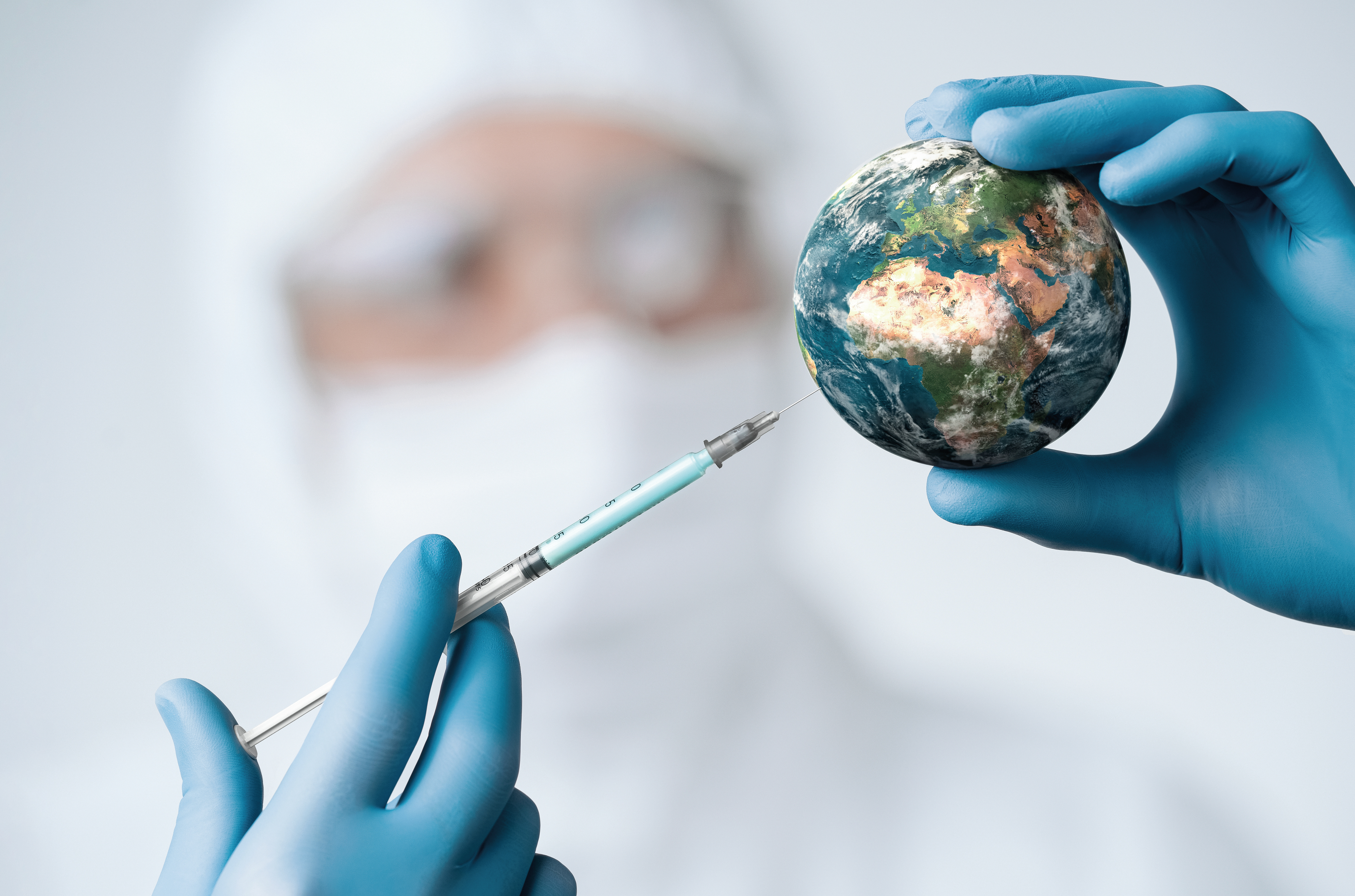En læge der sætter en sprøjte i en lille globus for at demonstrere, at Europa har brug for en vaccine mod abekopper