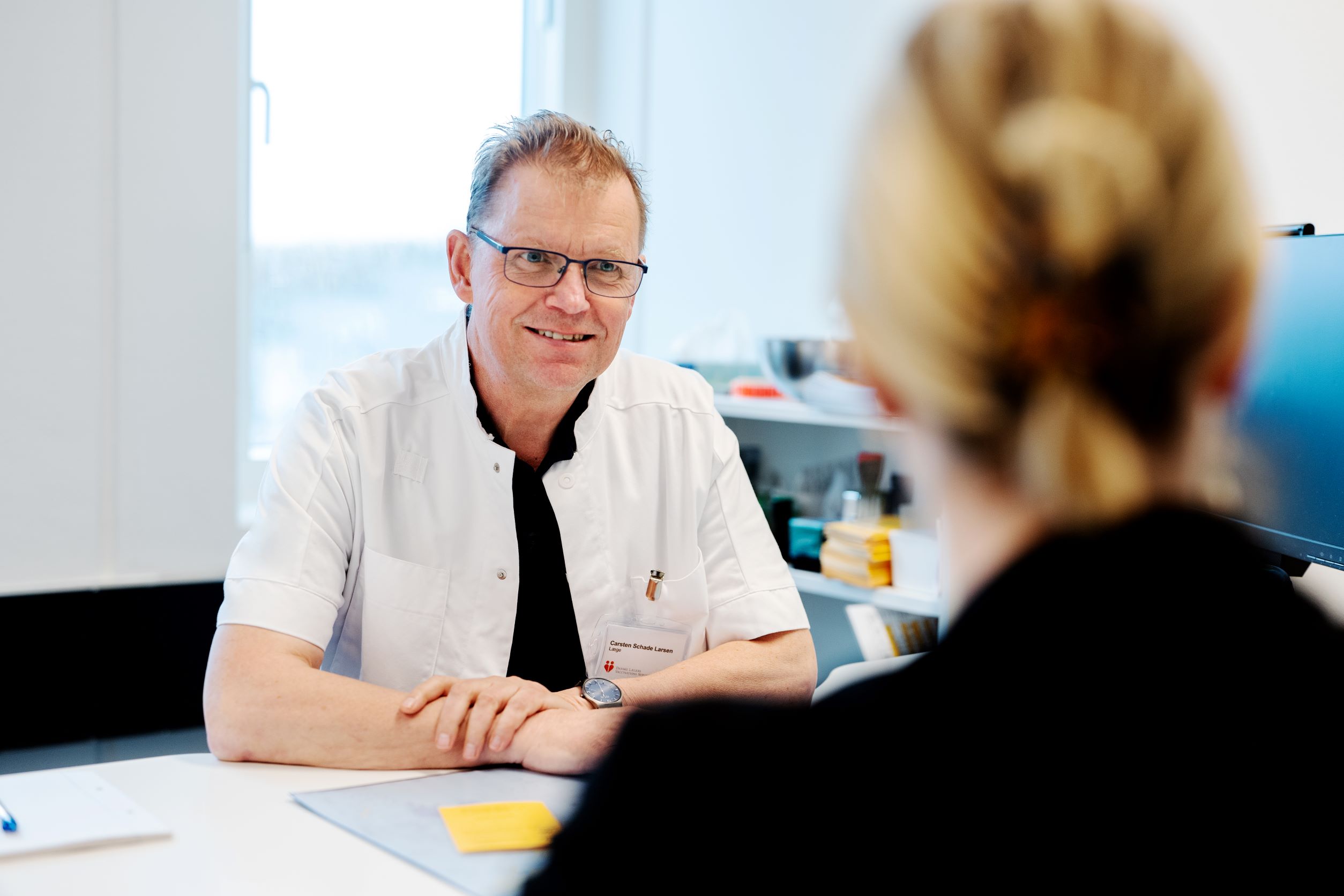 Cheflæge Carsten Schade Jensen har en kunde inde til konsultation for mantouxtest og tuberkulose test